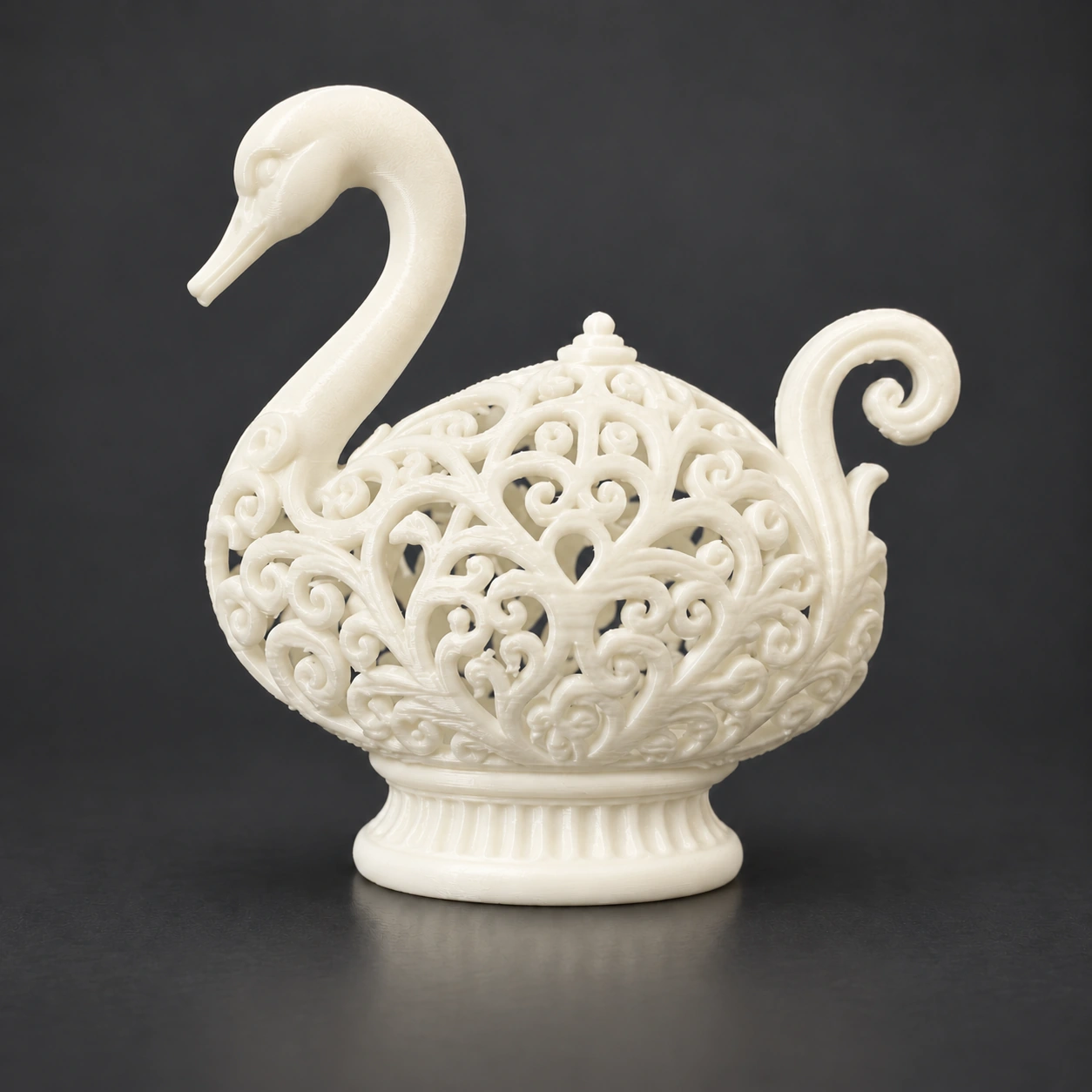 Enhanced solo photograph of an ivory-white filigree swan with a curved neck, curled tail and plain pedestal base