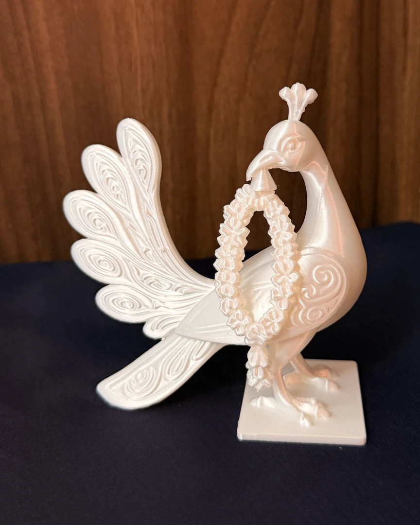 White peacock decor with floral garland, front three-quarter view